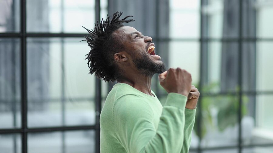 african-man-rejoices-victory-with-his-hands-up_709984-13861