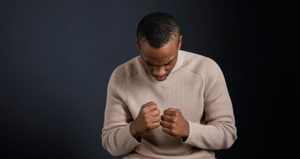 portrait-man-sitting-with-clenched-fists_23-2148854424